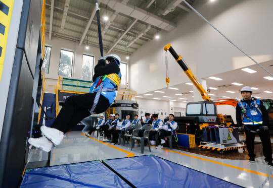 대림그룹 신입사원이 완강기 착용법을 숙지하고 하강하는 실습 교육을 받고 있다. <대림산업 제공>